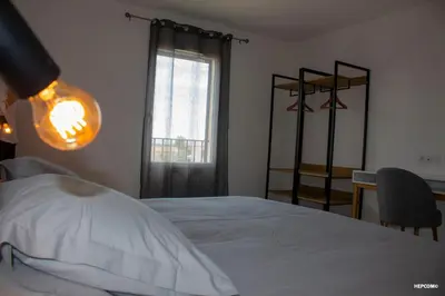 a bedroom with a white bed and a window at BASTIDE 9 in La Fare-les-Oliviers