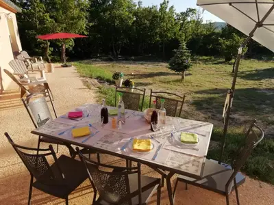 a table with a plate of food and an umbrella at LA MAGUETTE in Sault-de-Vaucluse