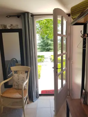 a sliding glass door leading to a patio with a porch at Les Néfliers chambre d'hôtes in Céreste