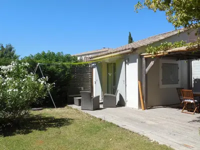 a patio with chairs and a house at La maison bleue in LʼIsle-sur-la-Sorgue