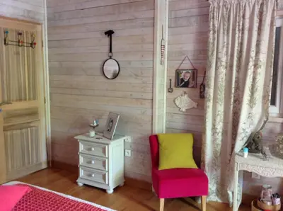 a bedroom with a bed and a chair and a table at La maison bleue in LʼIsle-sur-la-Sorgue