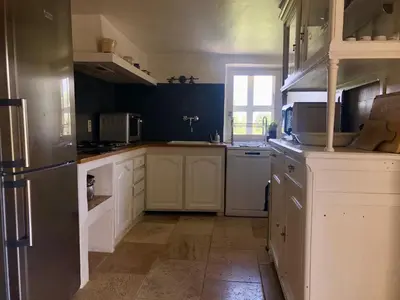 a kitchen with white cabinets and a refrigerator at La Magnanerie in Bonnieux