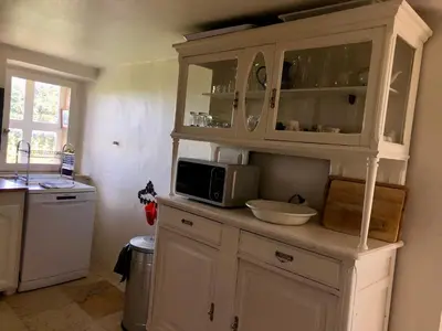 a kitchen with white cabinets and a microwave at La Magnanerie in Bonnieux