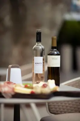 two bottles of wine and a plate of food on a table at Hôtel Boutique Cézanne centre Aix-en-Provence in Aix-en-Provence