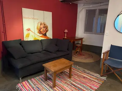 a living room with a black couch and a table at Charmante maison en centre ville d'Apt in Apt