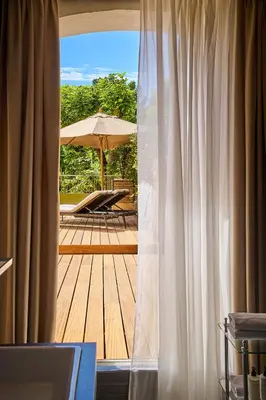 an open door to a deck with an umbrella at Le Pigonnet - Esprit de France in Aix-en-Provence