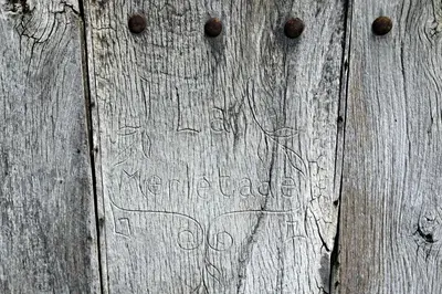 a sign on a wooden door with writing on it at Château de la Merletade in Cheval-Blanc