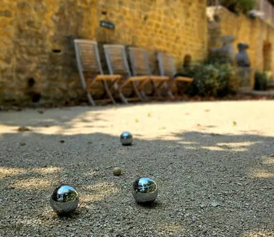 a group of balls on the ground with two chairs at Château de la Merletade in Cheval-Blanc