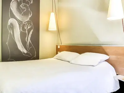 two beds in a room with a window at ibis Salon de Provence in Salon-de-Provence