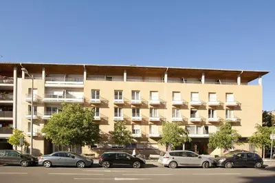 a large building with cars parked in front of it at Séjours & Affaires Aix-en-Provence Mirabeau in Aix-en-Provence
