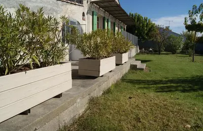 a row of potted plants sitting outside of a house at A 5 Minutes des Ocres Gïte La Charite Gordes Roussillon in Gargas