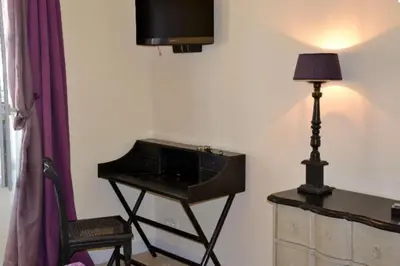 a room with a desk with a lamp and a piano at Mas Le 7 in Saint-Andiol