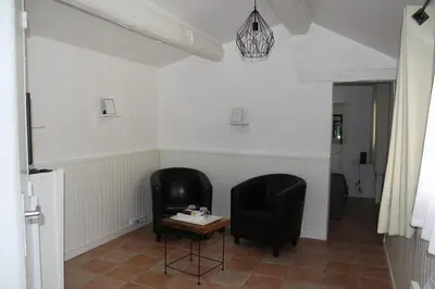 two black chairs and a table in a room at Le Mas des Chênes in Rognes