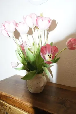 a vase filled with pink and white flowers on a table at Le Mas des Chênes in Rognes