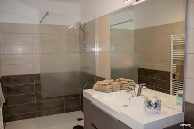 a bathroom with a sink and a shower with a mirror at BASTIDE 7 in La Fare-les-Oliviers