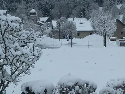 a snow covered yard with a house and trees at Mas Dansavan Chambres d'hôtes in Oppède