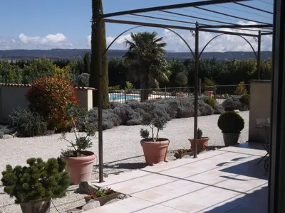 a garden with potted plants on a patio at Demeure d'hôtes et Mas Maurice in Oppède