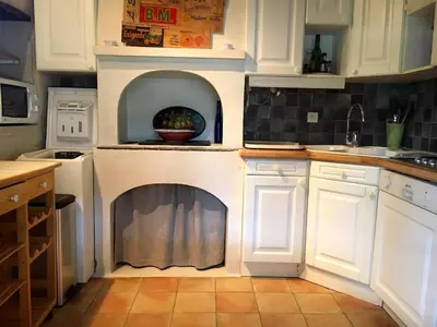 a kitchen with a fireplace in the middle of it at La Source à Bonnieux en Luberon in Bonnieux