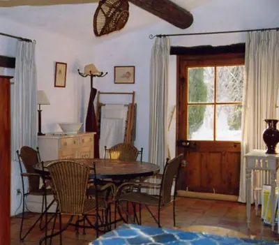 a dining room with a table and chairs and a window at La Source à Bonnieux en Luberon in Bonnieux