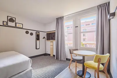 a hotel room with a bed and a table and a window at Appart'hôtel Odalys City - Aix en Provence Centre Palais des Congrès in Aix-en-Provence