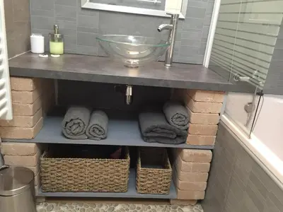 a bathroom with a shelf with towels and a sink at T2 avec TERRASSE, CLIM , box fibre in Vedène