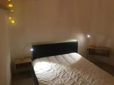 a bedroom with a bed with two lamps on two tables at T2 avec TERRASSE, CLIM , box fibre in Vedène