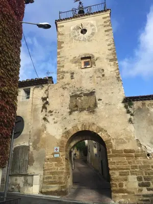 a building with a clock tower with an archway at T2 avec TERRASSE, CLIM , box fibre in Vedène