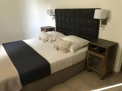 a bedroom with a large bed with a large headboard at Le Devem De Mirapier in Cornillon-Confoux