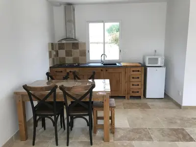 a kitchen with a table and chairs and a sink at Le Devem De Mirapier in Cornillon-Confoux