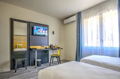 a hotel room with two beds and a desk at Best Western Domaine de Roquerousse in Salon-de-Provence