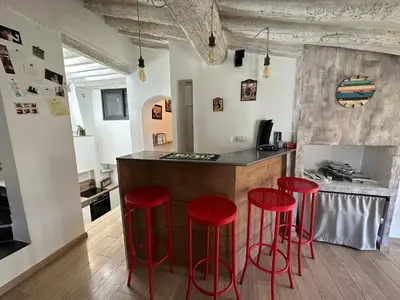 a kitchen with red stools at a kitchen counter at Toits Vieil Aix - Appartement de charme avec terrasse d'exception centre ville historique proche Cardeurs Et Mairie in Aix-en-Provence