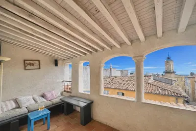 a living room with a couch and a large window at Toits Vieil Aix - Appartement de charme avec terrasse d'exception centre ville historique proche Cardeurs Et Mairie in Aix-en-Provence