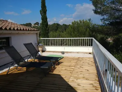 two chairs and a table on a wooden deck at Suite l'Escoundudo in Aix-en-Provence
