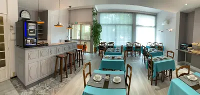 a restaurant with blue tables and chairs and a bar at Hotel du Midi in Salon-de-Provence