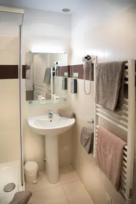 a small bathroom with a sink and a mirror at Hotel Toppin in Cavaillon