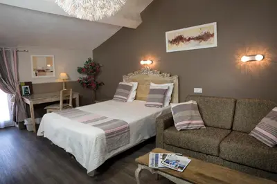a bedroom with a bed and a couch at Hotel Toppin in Cavaillon