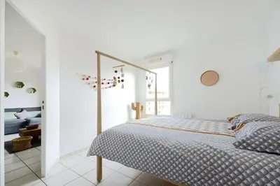 a white bedroom with a bed and a living room at T2 cosy proche du centre-ville avec garage inclus in Aix-en-Provence
