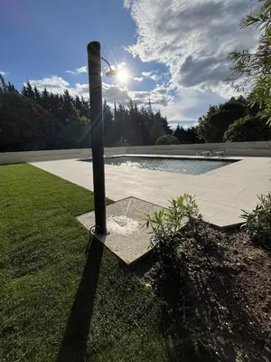 a pole in the grass next to a pool at Moulin de la Roque in Althen-des-Paluds