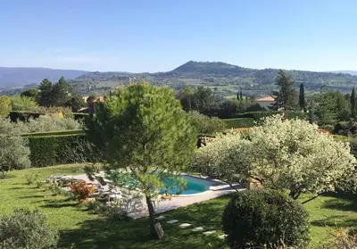 a garden with a swimming pool and trees at L'Atelier de Maia in Mormoiron