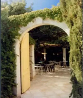 an archway with ivy growing over it with a table at Mas De La Tour in Gargas