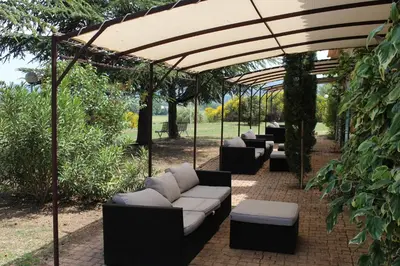 a group of couches sitting under a pergola at Mas De La Tour in Gargas