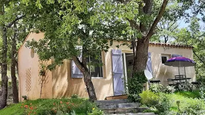 a house with an umbrella in front of it at Le Cabanon in Sainte-Croix-à-Lauze