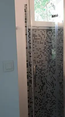 a bathroom with a glass shower with a window at Le Cabanon in Sainte-Croix-à-Lauze