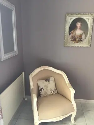 a chair with a pillow in a room with a painting at Logis Hôtel Le Manoir - Luberon in Apt