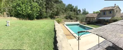 a backyard with a swimming pool and a house at typical provencal bastide, built of local stones, in the luberon in cheval-blanc with secured pool and wifi -sleeps 6 people. in Cheval-Blanc