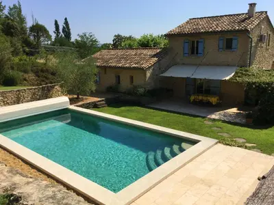 a swimming pool in front of a house at typical provencal bastide, built of local stones, in the luberon in cheval-blanc with secured pool and wifi -sleeps 6 people. in Cheval-Blanc