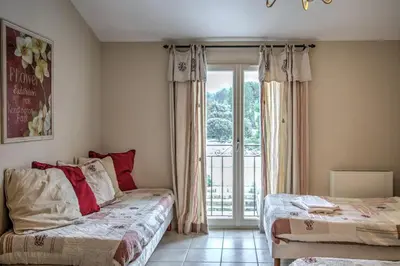 a bedroom with two beds and a sliding glass door at Mas Santoline in Eygalières
