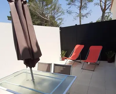 an umbrella on a glass table with two red chairs at Villa Quatra aux portes d'Aix-en-Provence in Éguilles