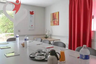 a room with a table with chairs and a red curtain at HOTEL RESTAURANT OLYMPE in Aix-en-Provence