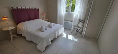 a bedroom with a bed with a table and a window at Les dentelles Évasion Provençale Villa avec Piscine et jardin in Carpentras
